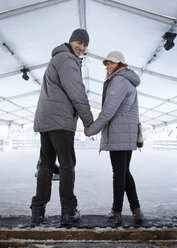 Couple standing at the ice rink - ZEDF01824