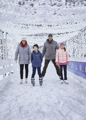 Familie mit zwei Kindern beim Schlittschuhlaufen auf der Eislaufbahn - ZEDF01835