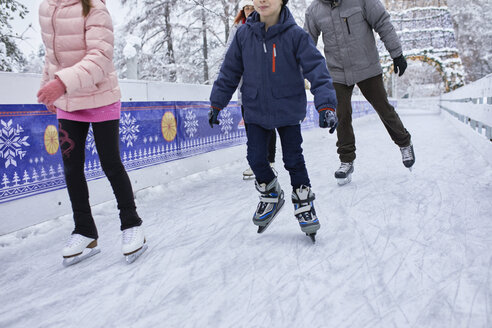 Familie mit zwei Kindern beim Schlittschuhlaufen auf der Eislaufbahn - ZEDF01838