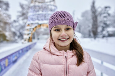 Porträt eines Mädchens mit Wollmütze, das sich beim Schlittschuhlaufen auf der Eisbahn amüsiert - ZEDF01841