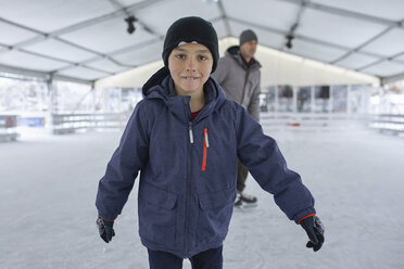 Vater und Sohn laufen gemeinsam Schlittschuh und haben Spaß auf der Eisbahn - ZEDF01846