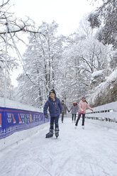 Familie mit zwei Kindern beim Schlittschuhlaufen auf der Eislaufbahn - ZEDF01859