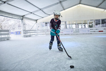 Boy playing ice hockey on the ice rink - ZEDF01864