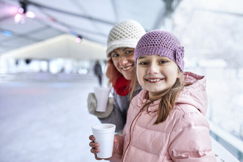 Mutter und Tochter trinken heiße Schokolade auf der Eislaufbahn - ZEDF01870