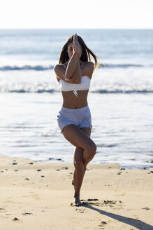 Sportliche Frau beim Yoga am Strand - JSMF00774