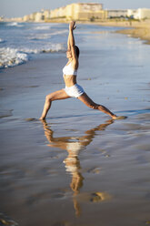 Sportliche Frau beim Yoga am Strand - JSMF00776