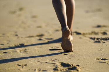 Nahaufnahme von Frauenfüßen, die im Sand am Strand laufen - JSMF00783