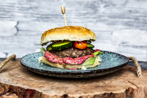 Hamburger mit Rote-Bete-Hummus, Gurke, Tomate und Salat, lizenzfreies Stockfoto