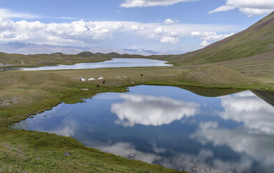 Wolken spiegeln sich in Seen in einem Tal, entfernte Bergkette, Tulpar Kul, Kirgisistan. - MINF10103