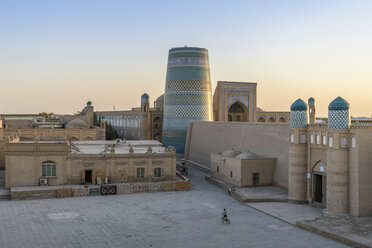 Elevated view over the courtyard of historic monuments with Kalta Minor minaret in the centre of Khiva, Uzbekistan. - MINF10112