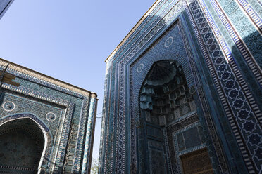 Low angle view of tall arches of an Islamic Madrasa building with blue and white patterned glazed tiles. - MINF10132