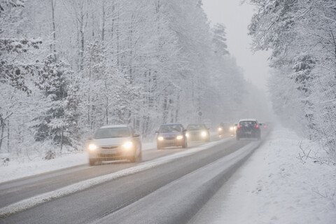 Cars driving on country road in winter, driving snow stock photo