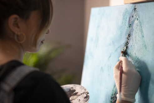 Junge Frau malt in ihrem Atelier - GRSF00063