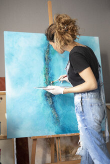 Junge Frau malt in ihrem Atelier - GRSF00064