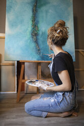 Junge Frau malt in ihrem Atelier - GRSF00066
