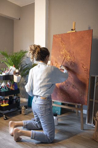 Junge Frau malt in ihrem Atelier, lizenzfreies Stockfoto