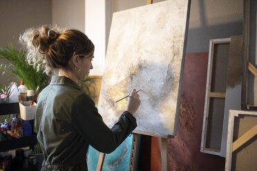 Junge Frau malt in ihrem Atelier - GRSF00073
