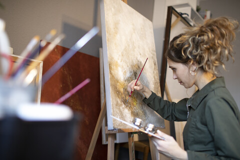 Young woman painting in her atelier stock photo