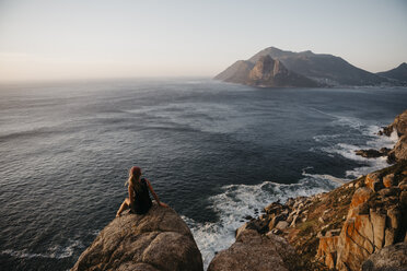 Südafrika, Westkap, Frau sitzt auf einem Felsen und betrachtet die Aussicht, gesehen vom Chapman's Peak Drive - LHPF00410