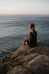 Südafrika, Westkap, Frau auf einem Felsen sitzend mit Blick auf die Aussicht - LHPF00413