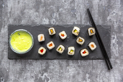 Sushi auf einem Teller, Wasabi in einer Schale, Essstäbchen, lizenzfreies Stockfoto