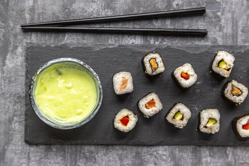 Sushi auf einem Teller, Wasabi in einer Schale, Essstäbchen - SARF04069
