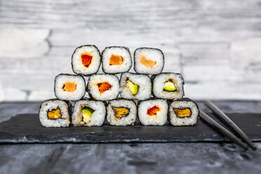 Gestapeltes Sushi auf Schieferplatte, Stäbchen - SARF04070