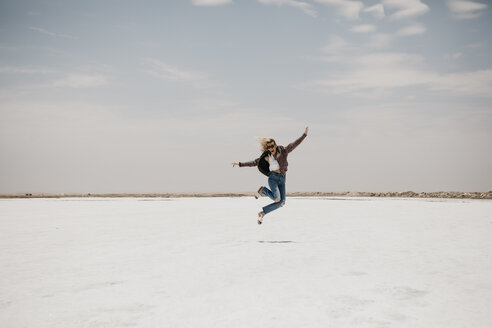 Namibia, Walvis Bay, Frau springt auf einer Salzebene - LHPF00421