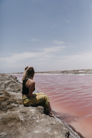 Namibia, Walvis Bay, Frau sitzt an den Rosa Lagunen, lizenzfreies Stockfoto