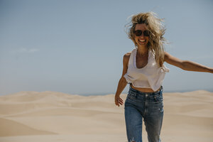 Namibia, Walvis Bay, Namib-Naukluft-Nationalpark, Sandwich Harbour, glückliche Frau in Dünenlandschaft - LHPF00433