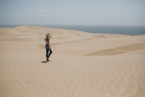 Namibia, Walvis Bay, Namib-Naukluft National Park, Sandwich Harbour, woman walking in dune landscape stock photo