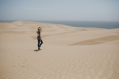 Namibia, Walvis Bay, Namib-Naukluft-Nationalpark, Sandwich Harbour, Frau geht in Dünenlandschaft - LHPF00434