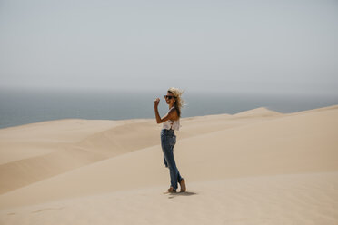 Namibia, Walvis Bay, Namib-Naukluft National Park, Sandwich Harbour, happy woman in dune landscape - LHPF00435