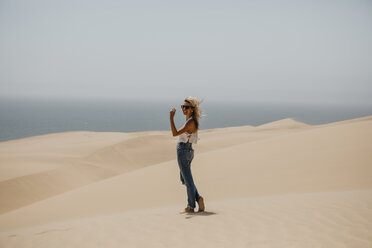 Namibia, Walvis Bay, Namib-Naukluft-Nationalpark, Sandwich Harbour, glückliche Frau in Dünenlandschaft - LHPF00435