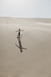 Namibia, Walvis Bay, Namib-Naukluft National Park, Sandwich Harbour, woman running in dune landscape - LHPF00444