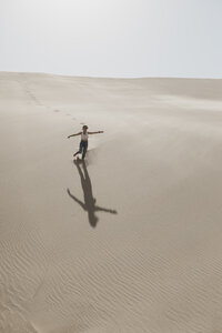 Namibia, Walvis Bay, Namib-Naukluft-Nationalpark, Sandwich Harbour, Frau läuft in Dünenlandschaft - LHPF00444
