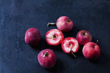Sliced and whole red-fleshed apples on dark ground - CSF29292