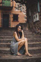 Spanien, Tarragona, Porträt einer Frau, die im Sommer auf einer Treppe sitzt - ACPF00400