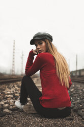 Portrait of fashionable young woman wearing cap and red pullover outdoors - ACPF00402