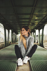 Young woman woman sitting in an abandoned train car - ACPF00403