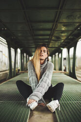 Porträt einer jungen Frau, die in einem verlassenen Zugwaggon sitzt - ACPF00404