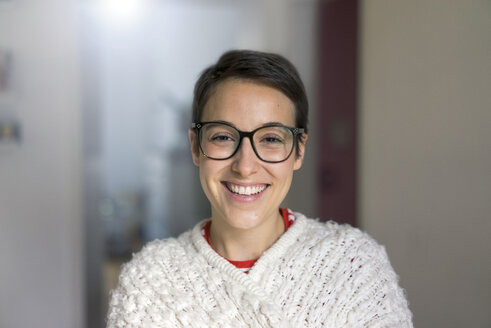 Porträt einer lächelnden jungen Frau mit kurzen Haaren, die eine Brille trägt - MOEF01941