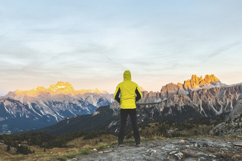 Italien, Drei Zinnen, Mann genießt bunte Berggipfel bei Sonnenuntergang, lizenzfreies Stockfoto