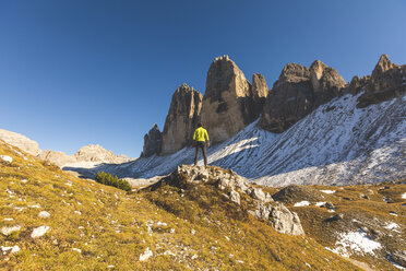Italy, Tre Cime di Lavaredo, man hiking and standing in front of the majestic three peaks - WPEF01330