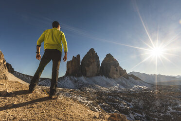 Italy, Tre Cime di Lavaredo, man hiking and standing in front of the majestic three peaks - WPEF01332