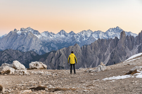 Italy, Tre Cime di Lavaredo, man enjoying colourful mountain peaks at sunset stock photo