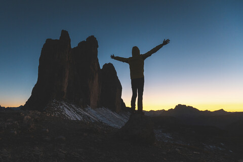 Italien, Drei Zinnen, Silhouette eines Mannes und die drei Gipfel in der Abenddämmerung, lizenzfreies Stockfoto