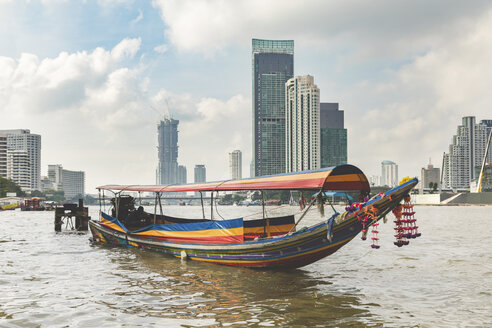 Thailand, Bangkok, typical boat on Chao Phraya river with city skyscrapers in background - WPEF01345