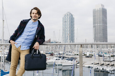 Spain, Barcelona, relaxed man after work with port and city background - JRFF02513