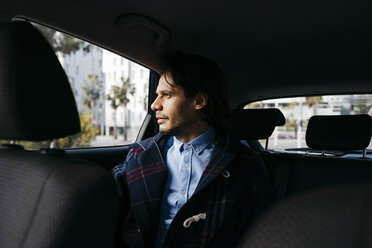 Mann sitzt auf dem Rücksitz eines Autos und schaut aus dem Fenster - JRFF02526